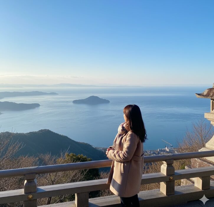 大山阿夫利神社の下社からの絶景。相模湾と江の島を一望できる冬の澄んだパノラマと、新年の抱負を固める日本人の女性。